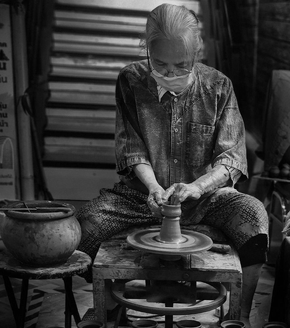 Photo of mature woman spinning pottery for AgeInc.
